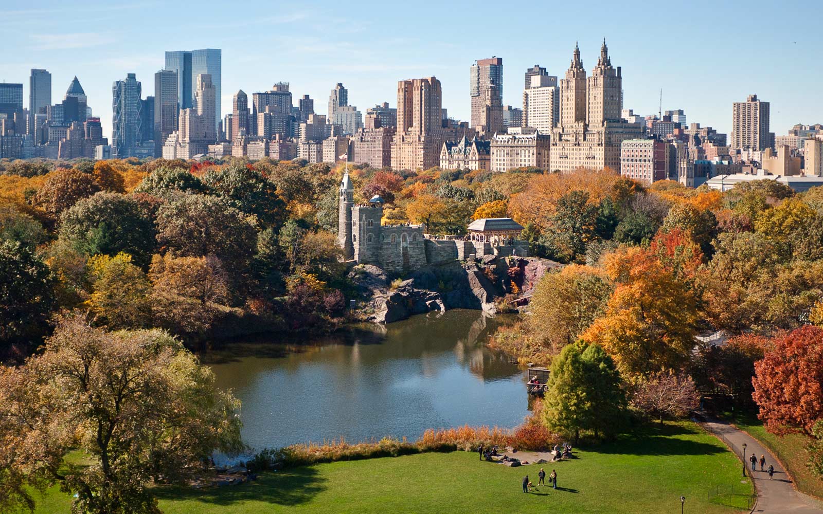 Aerial view of Belvedere Castle and Turtle Pond in nuzzled in the fall foilage in Central Park. Buildings lining Central Park West including The Majestic, Dakota, Langham, San Remo, and Time Warner Center are prominently featured in the skyline.