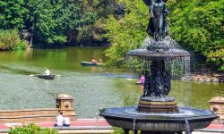 People relaxing and enjoying  a sunny day in Central Park at  Bethesda fountain. Free time leisure and travel concept. New York City. United States.